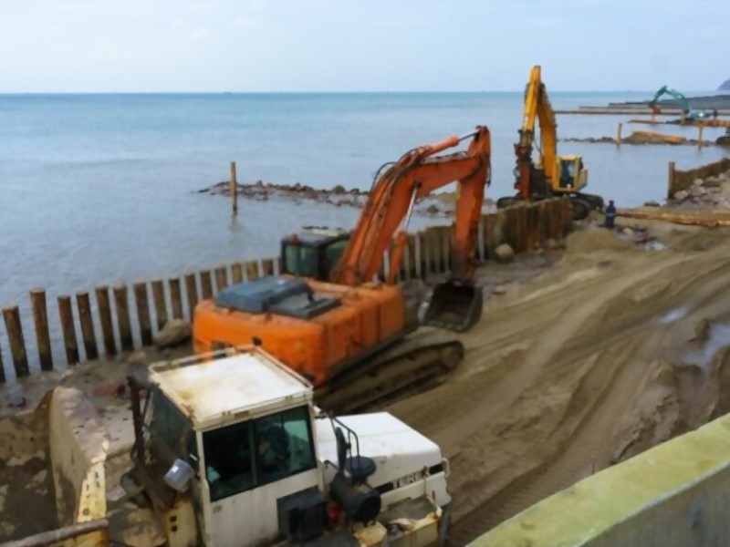 excavators near the shore